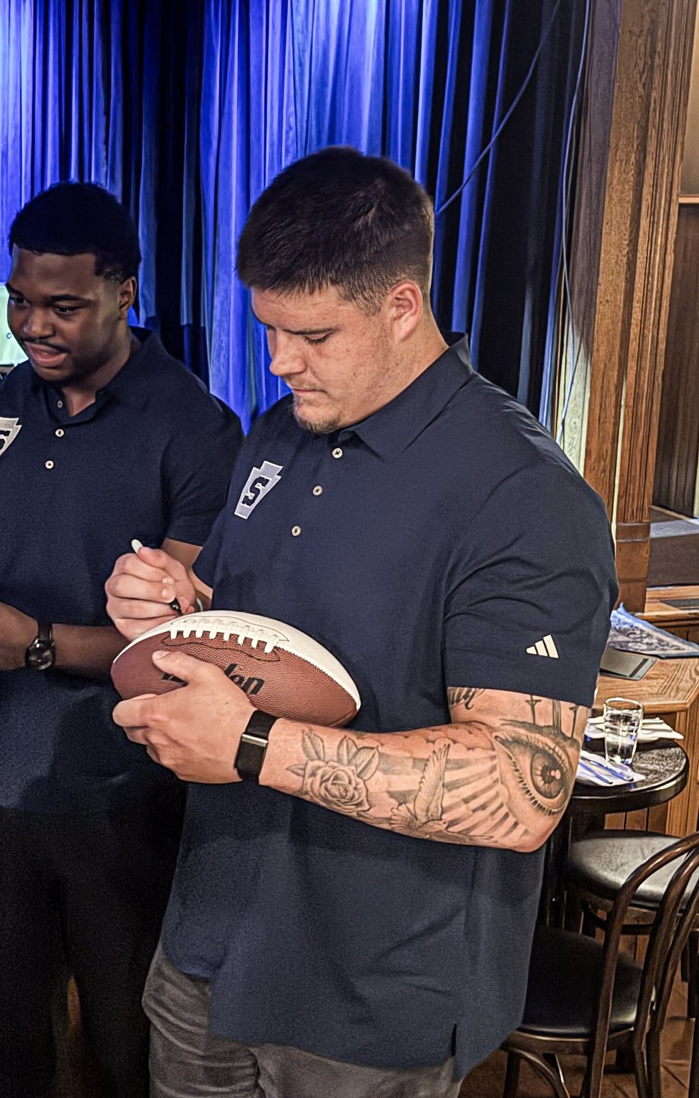 A Penn State player signs a football
