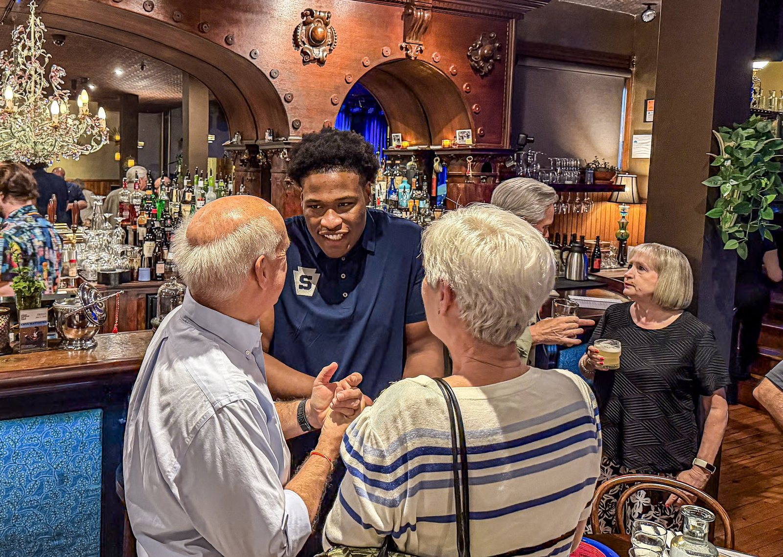 A Penn State player greets two members