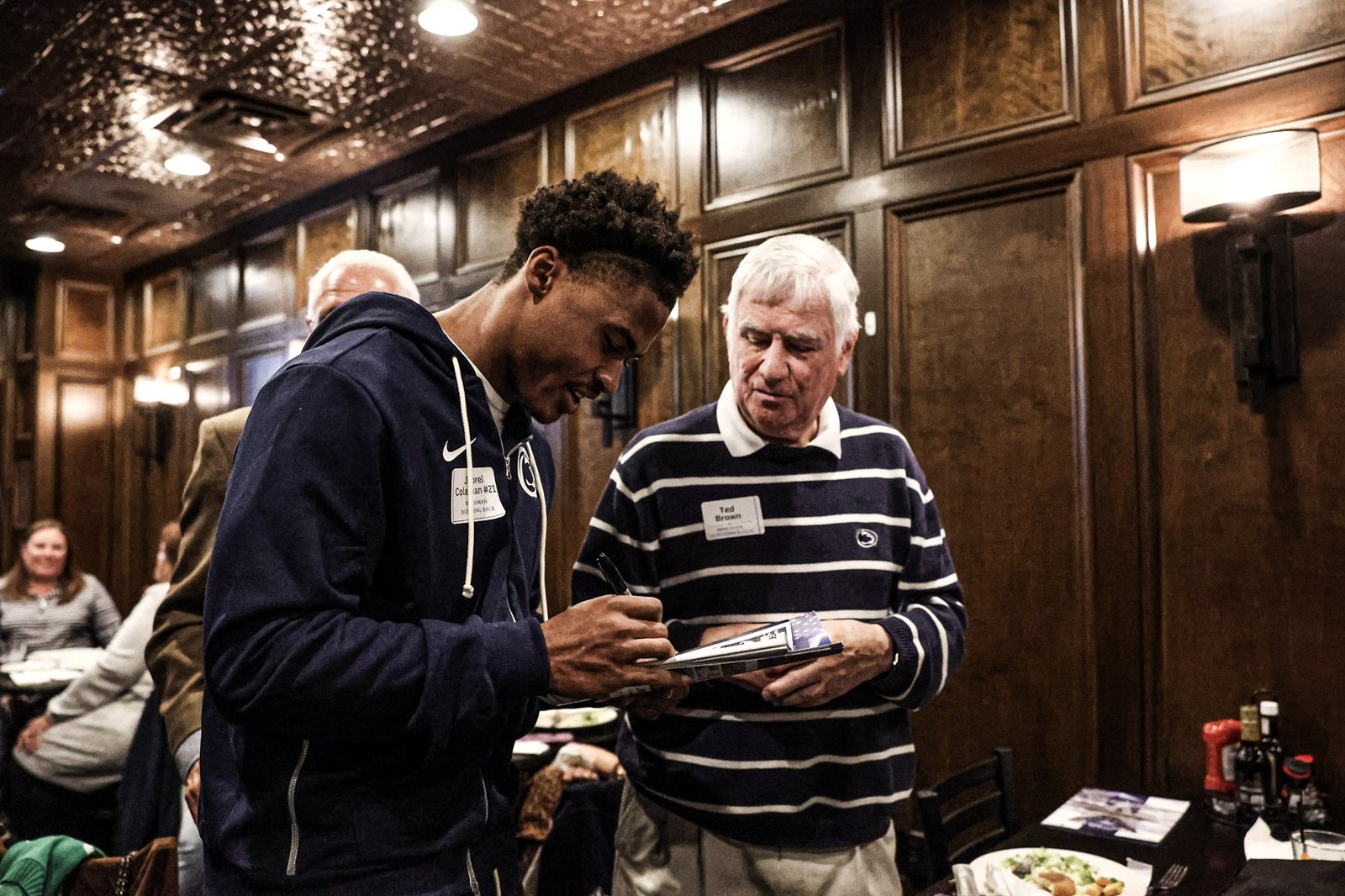 A Penn State player signs for a member